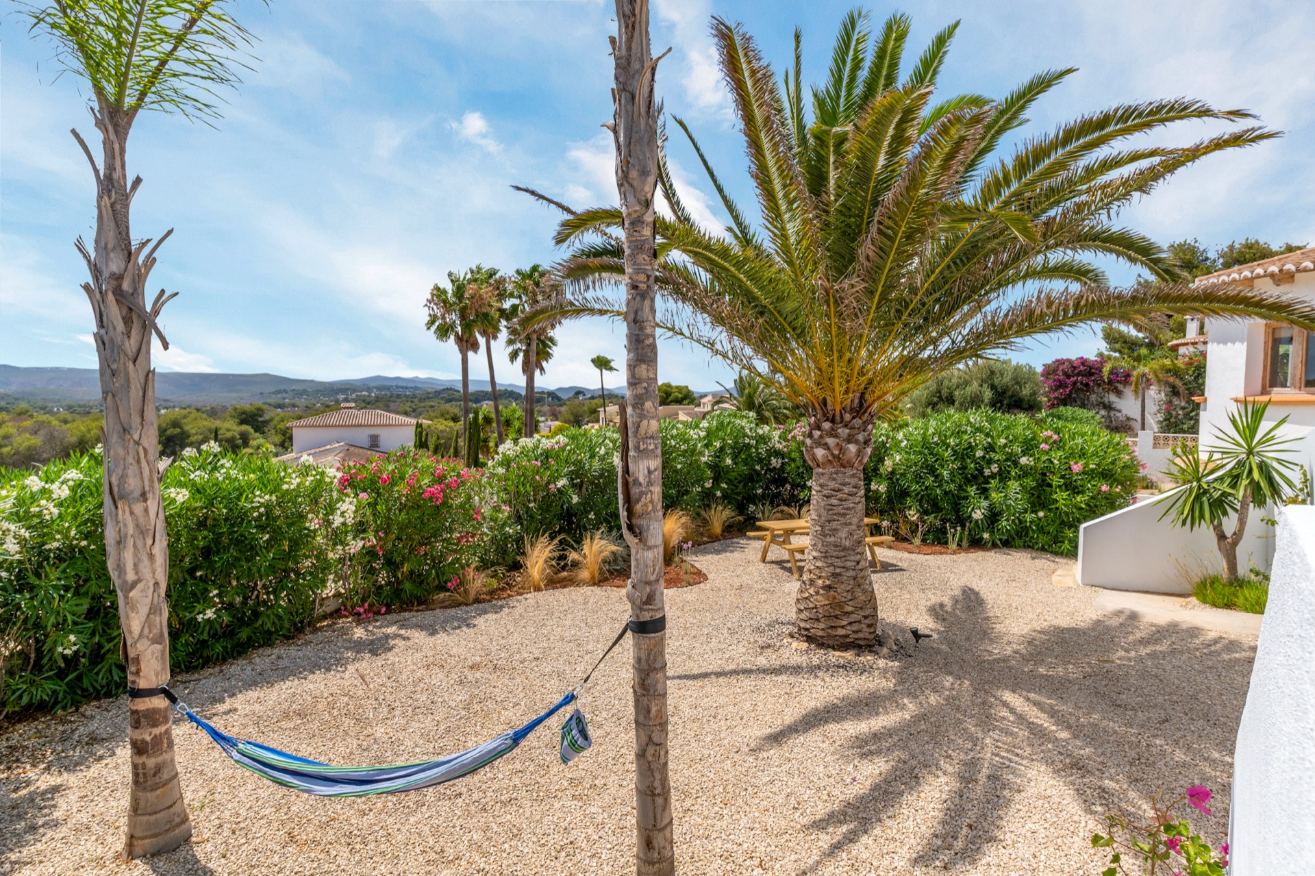 Mediterrane tuin van Casa Monte Zen met hangmat tussen de palmen